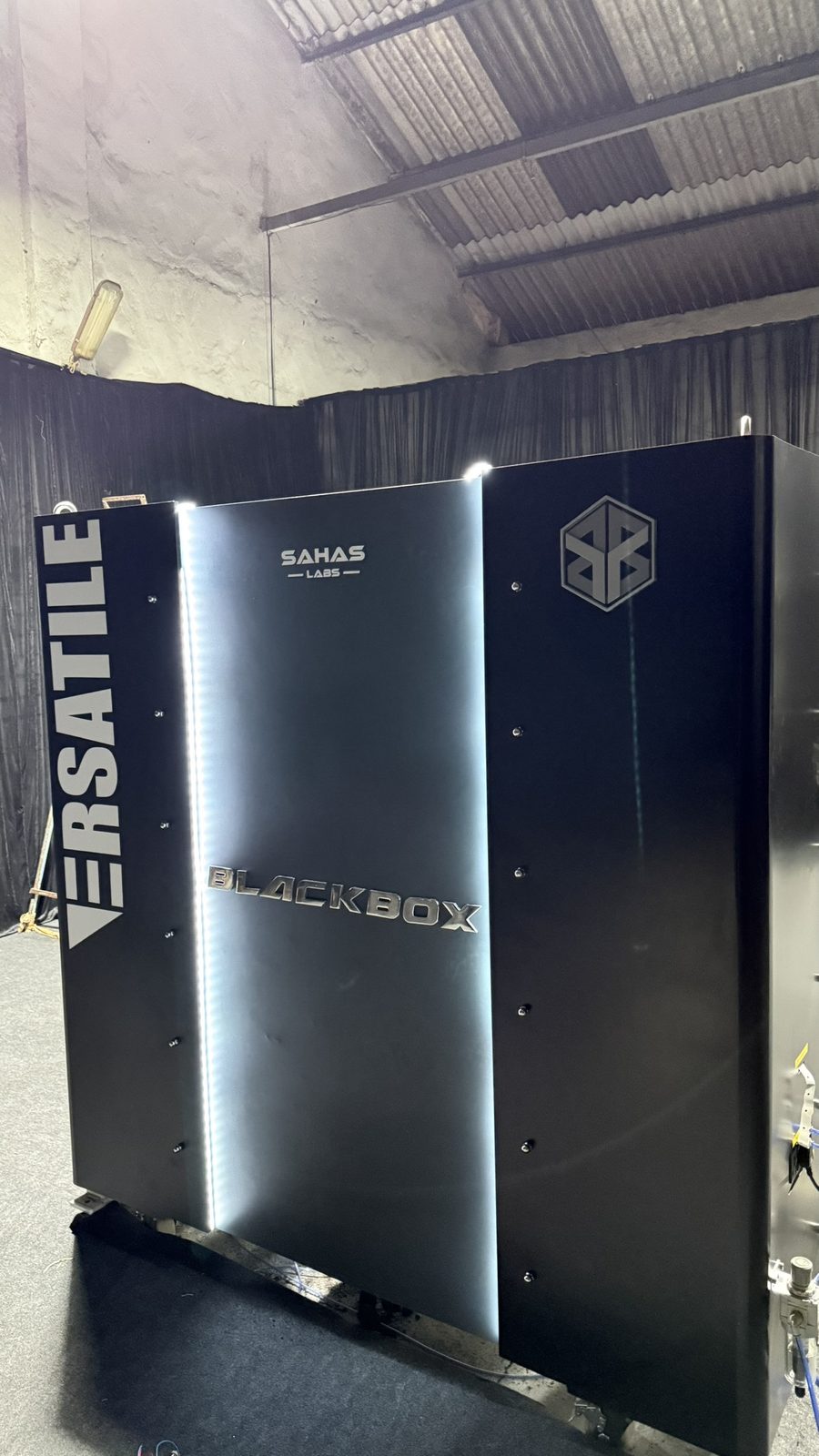 The Black Box cabinet seen from the front, with the Versatile and Sahas Labs marks on its brushed steel door
